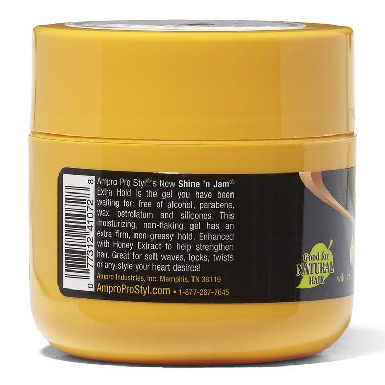 Bagside af en gul plastikkrukke med Ampro Shine 'n Jam Conditioning Gel. Etiketten indeholder produktinformationer som ingredienser, anvendelsesvejledning og fordele. Produktet er velegnet til naturligt hår og giver ekstra hold uden at være fedtet.