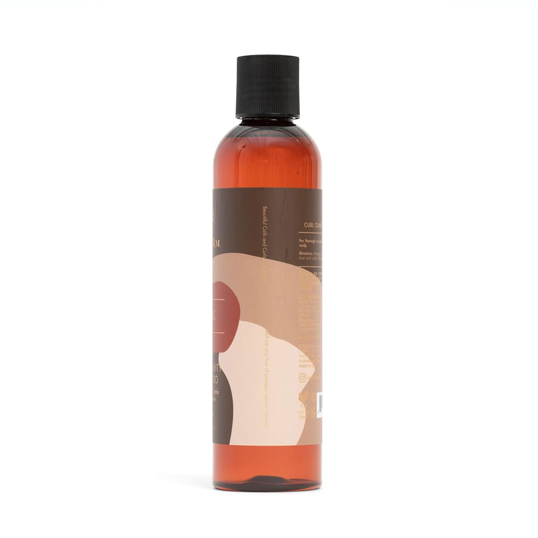 Bagside af en brun shampoo-flaske med en hvid etiket. Flasken indeholder As I Am Curl Clarity Shampoo og viser ingrediensliste og brugsanvisning.