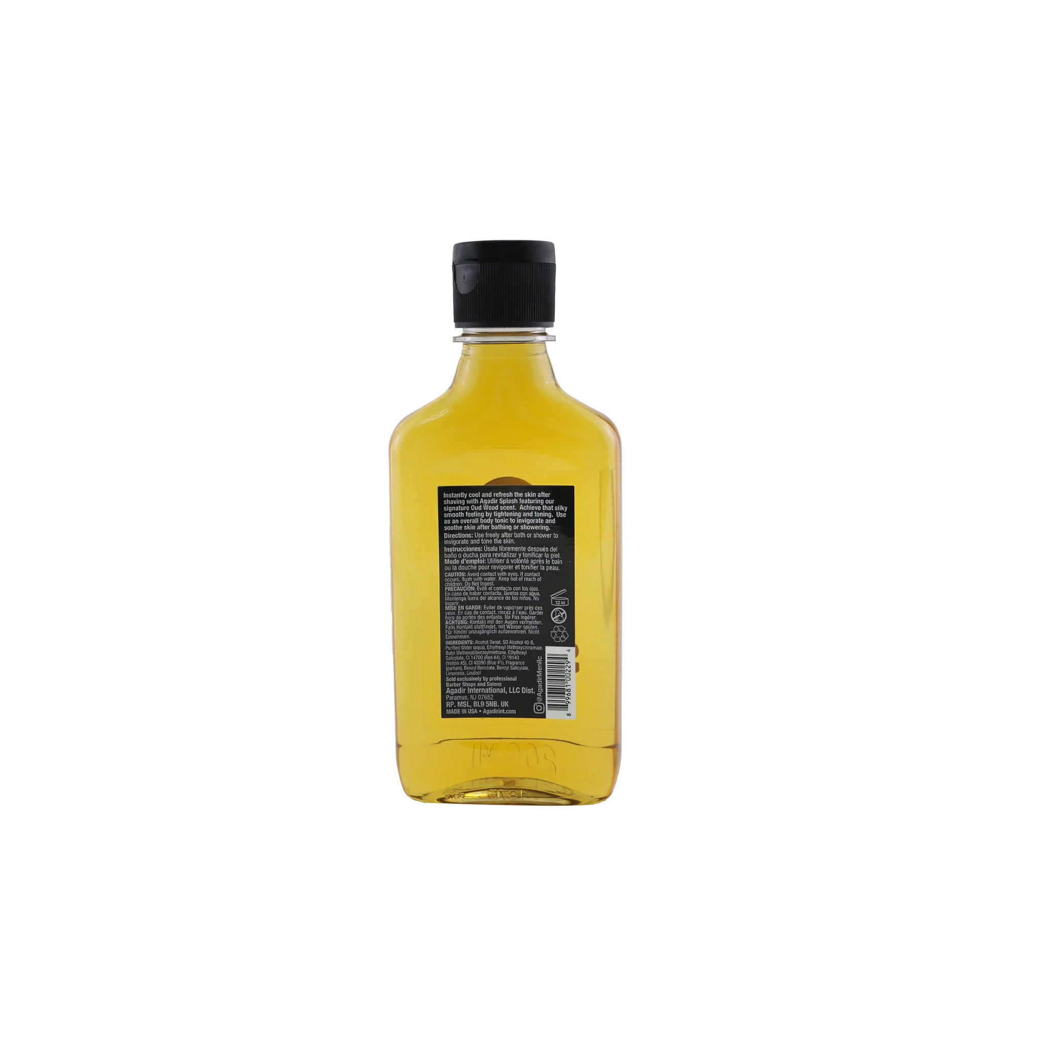 Bagside af en gennemsigtig flaske med Agadir Men Oud Wood Face & Body Splash. Etiketten viser produktoplysninger, herunder ingredienser og brugsanvisning. Produktet er angivet som en forfriskende body splash.