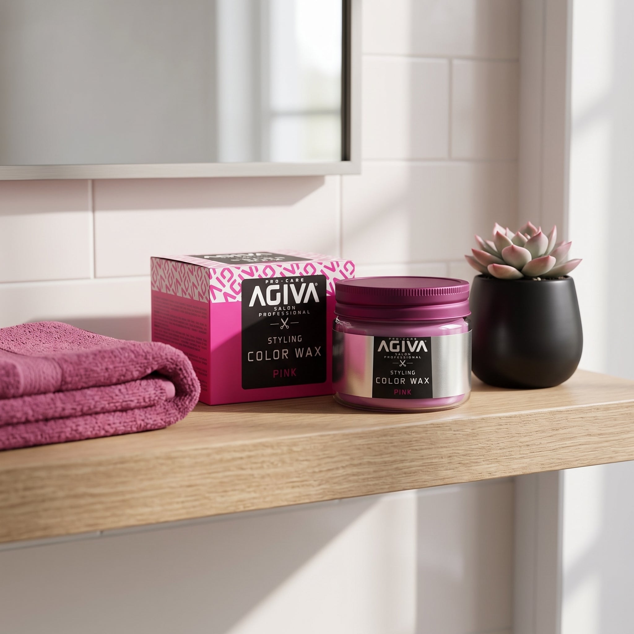 AGIVA Color Wax Pink glas og æske på træhylde med lyserødt håndklæde og lille sukkulent i sort potte.
