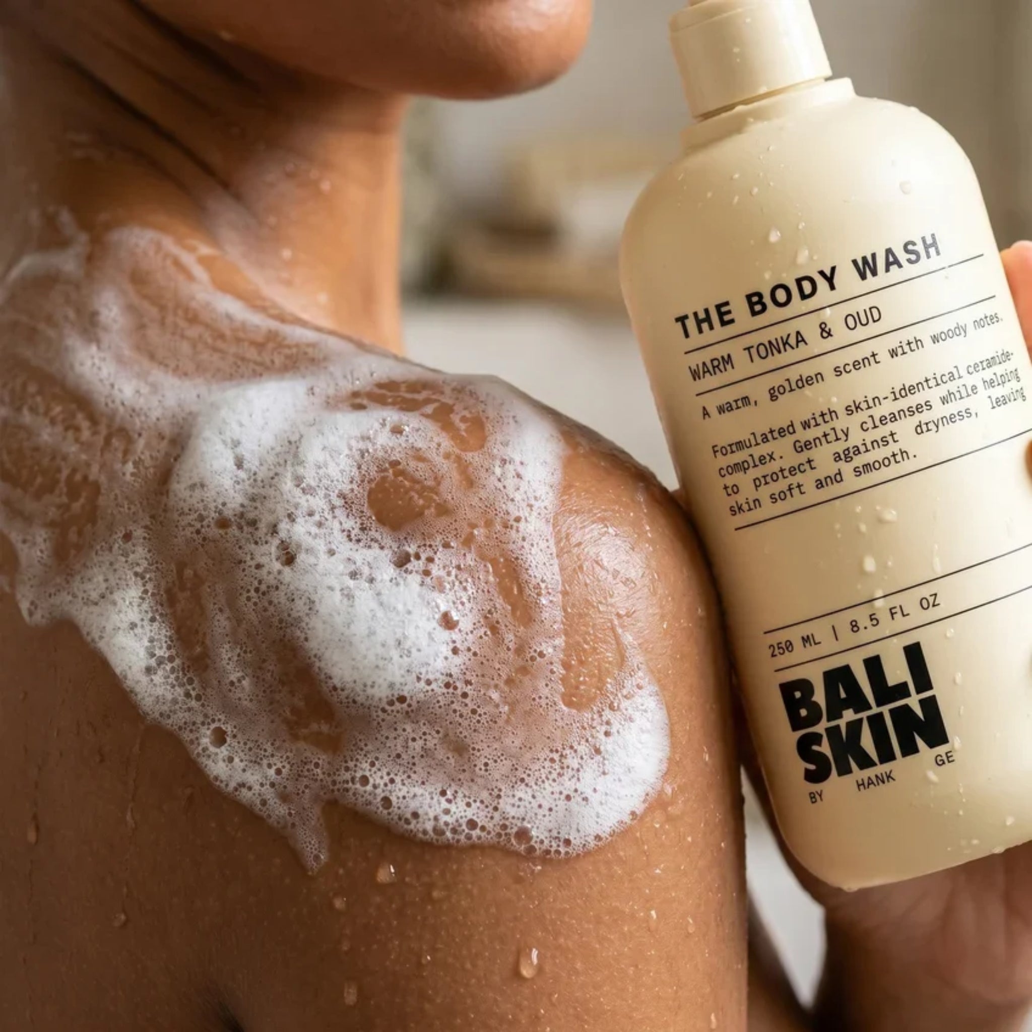 Bali Skin The Body Wash med Warm Tonka & Oud skum på skulder under bruser.