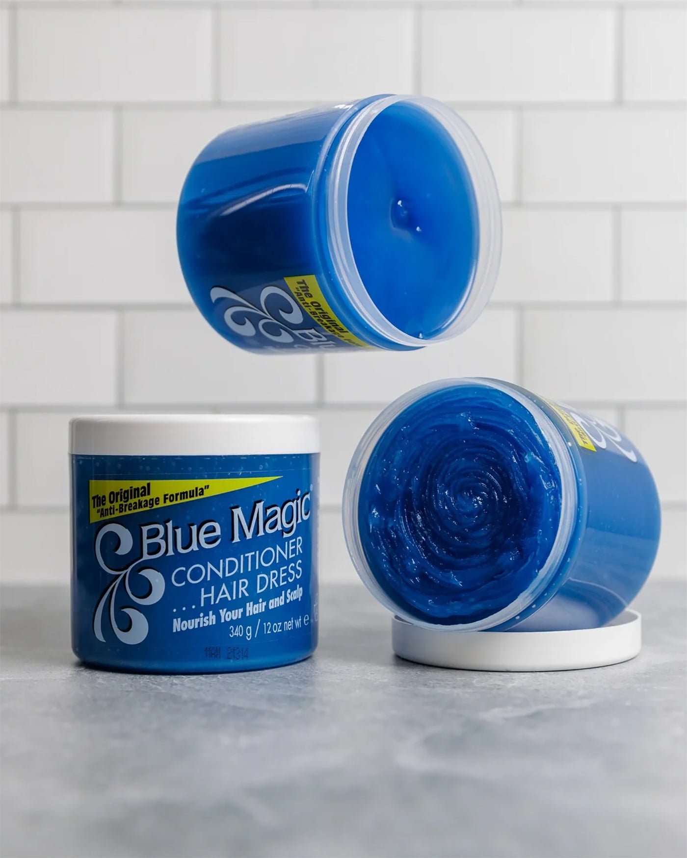 Tre bøtter Blue Magic Conditioner Hair Dress. En lukket, to åbne med den karakteristiske blå creme.