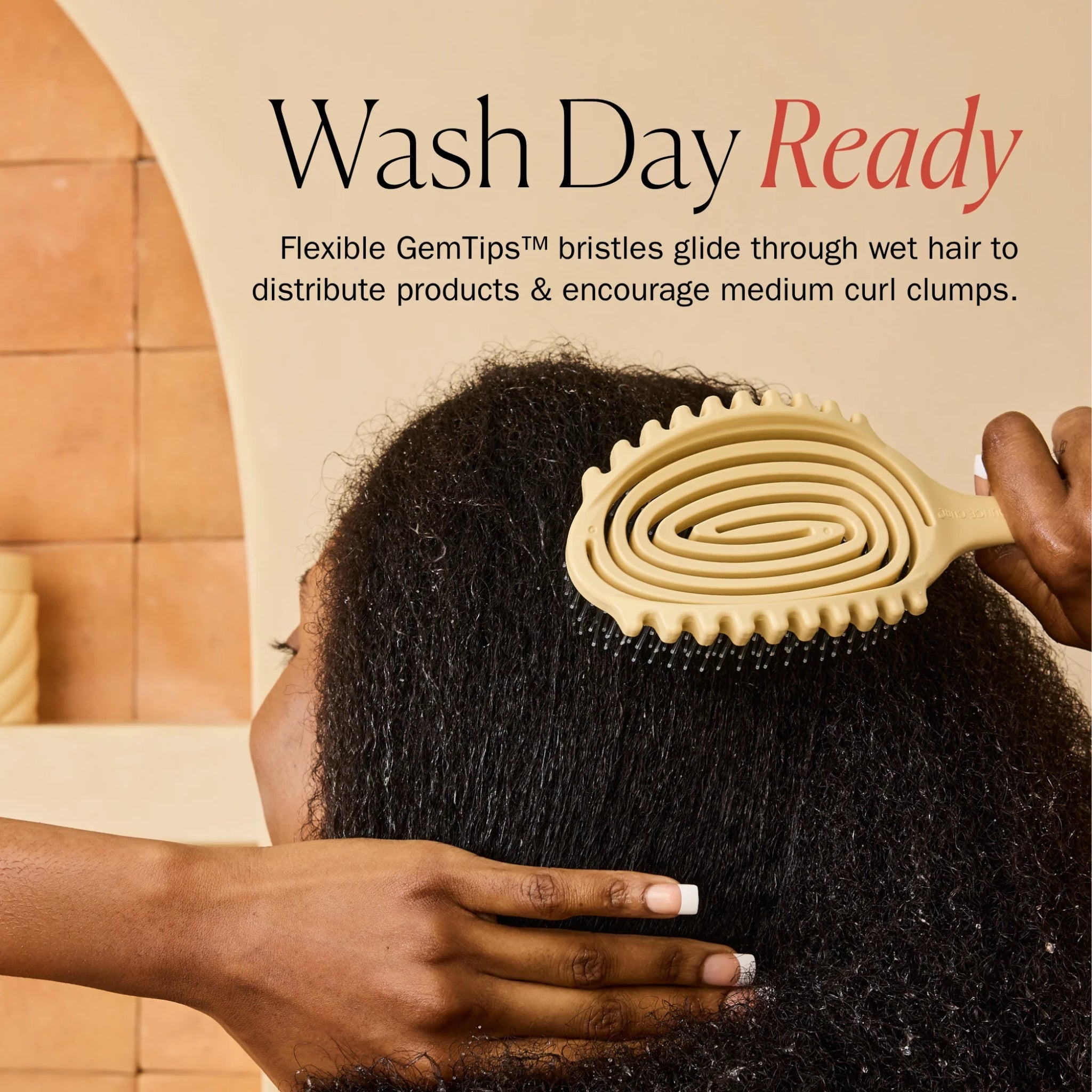 Gul spiralformet hårbørste med GemTips-bryster gennem vådt afro-hår under wash day rutine.