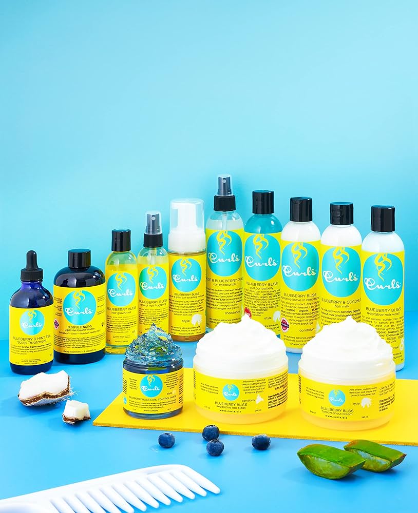 Curls Blueberry Bliss produkter: Hårplejeserie med blåbær, aloe vera og hvid kam på blå baggrund. Inkluderer reparative hårprodukter.