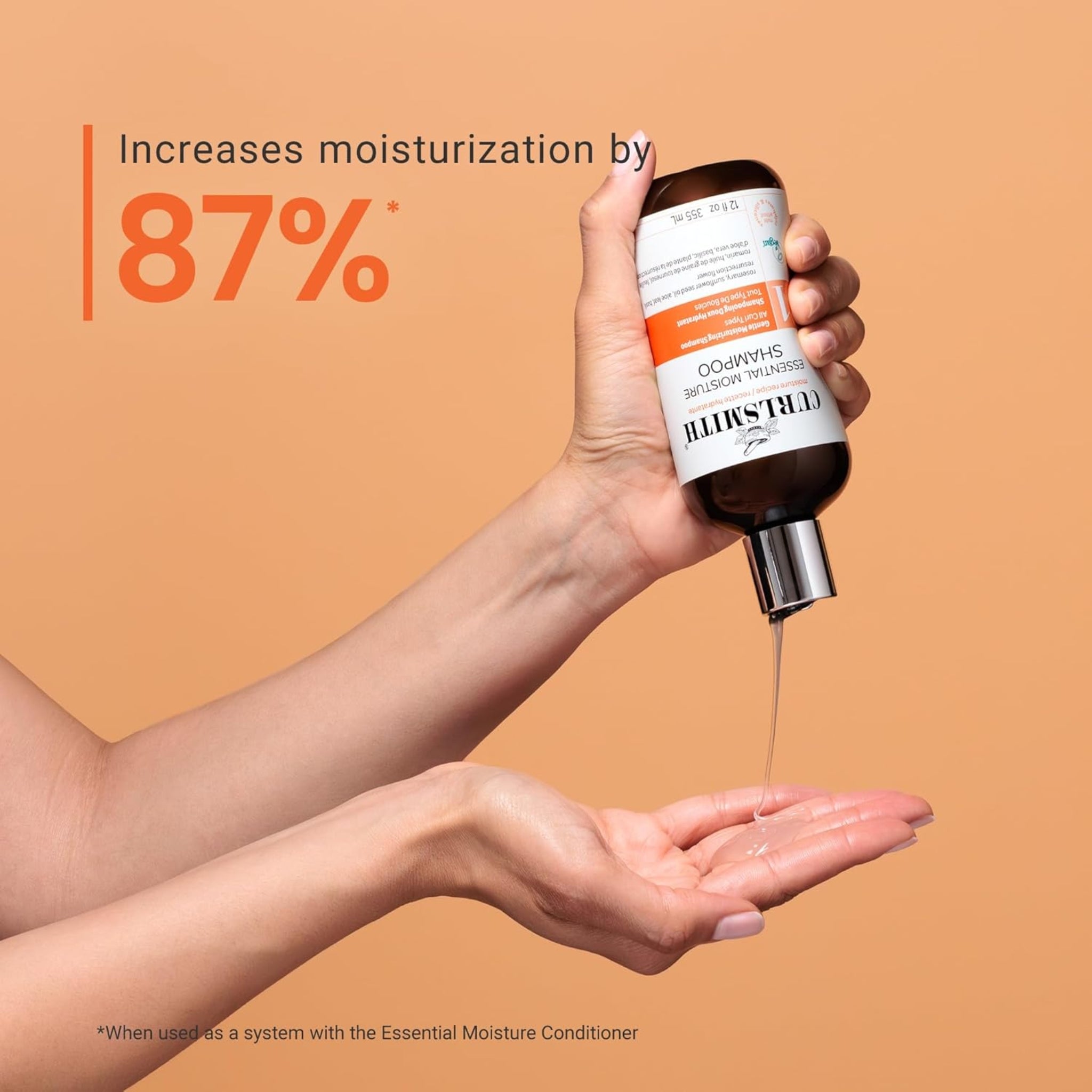 Curlsmith Essential Moisture Shampoo hældes i hånd, tekst viser 87% øget fugt i håret.