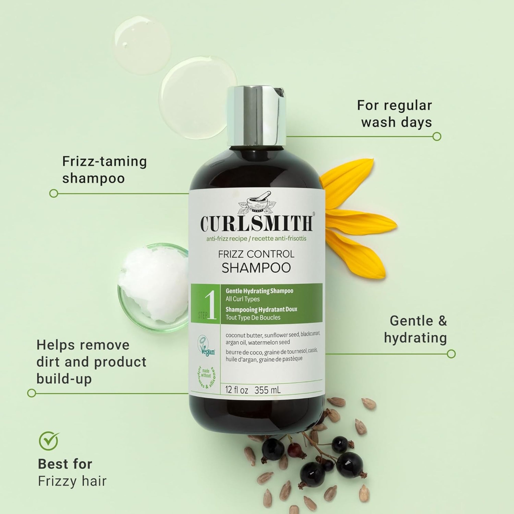 Curlsmith Frizz Control Shampoo, mørk flaske med grønt etiket, omgivet af kokosolie, solsikkeblomst og solbær.