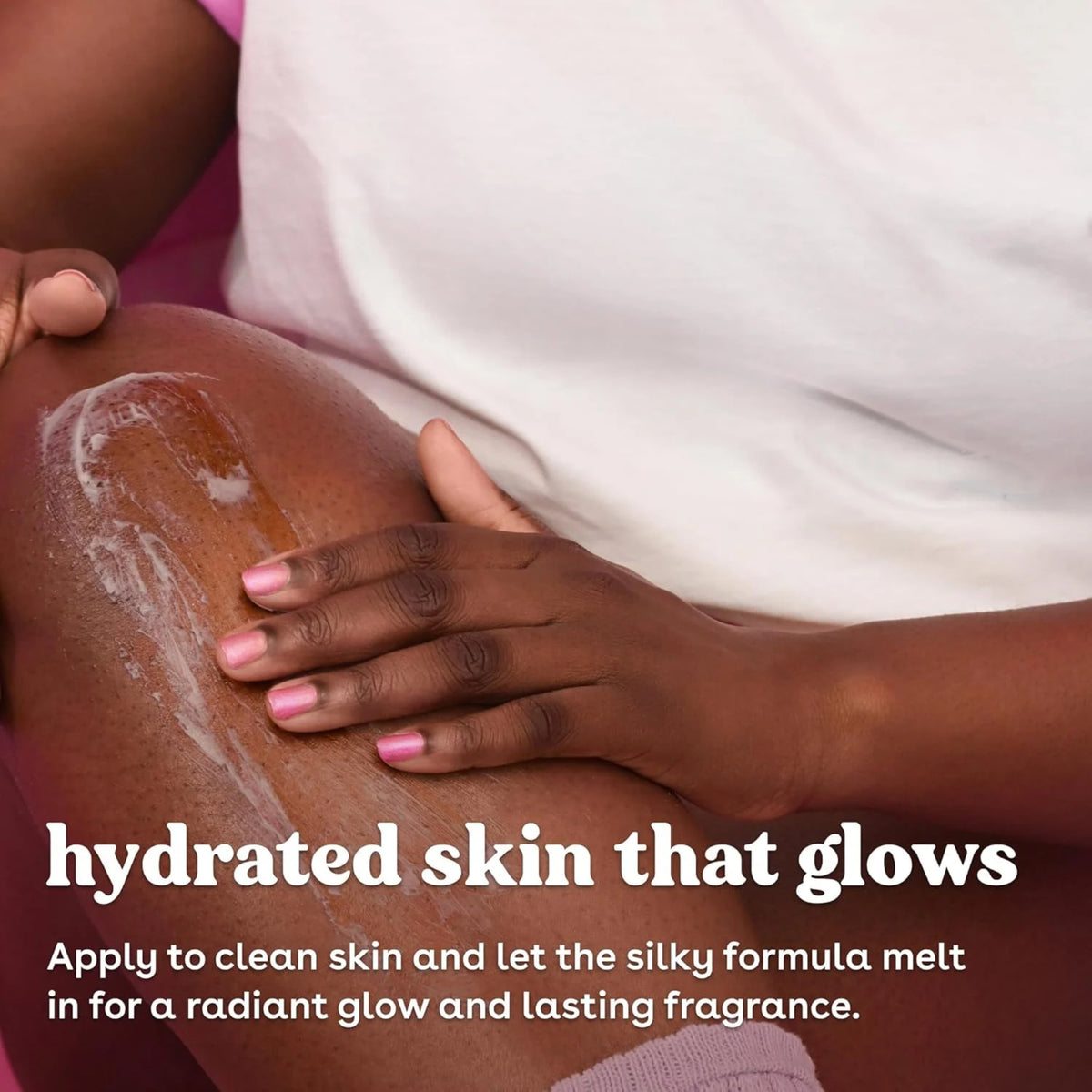Hånd med lyserøde negle masserer body lotion ind i huden for hydreret skin that glows.