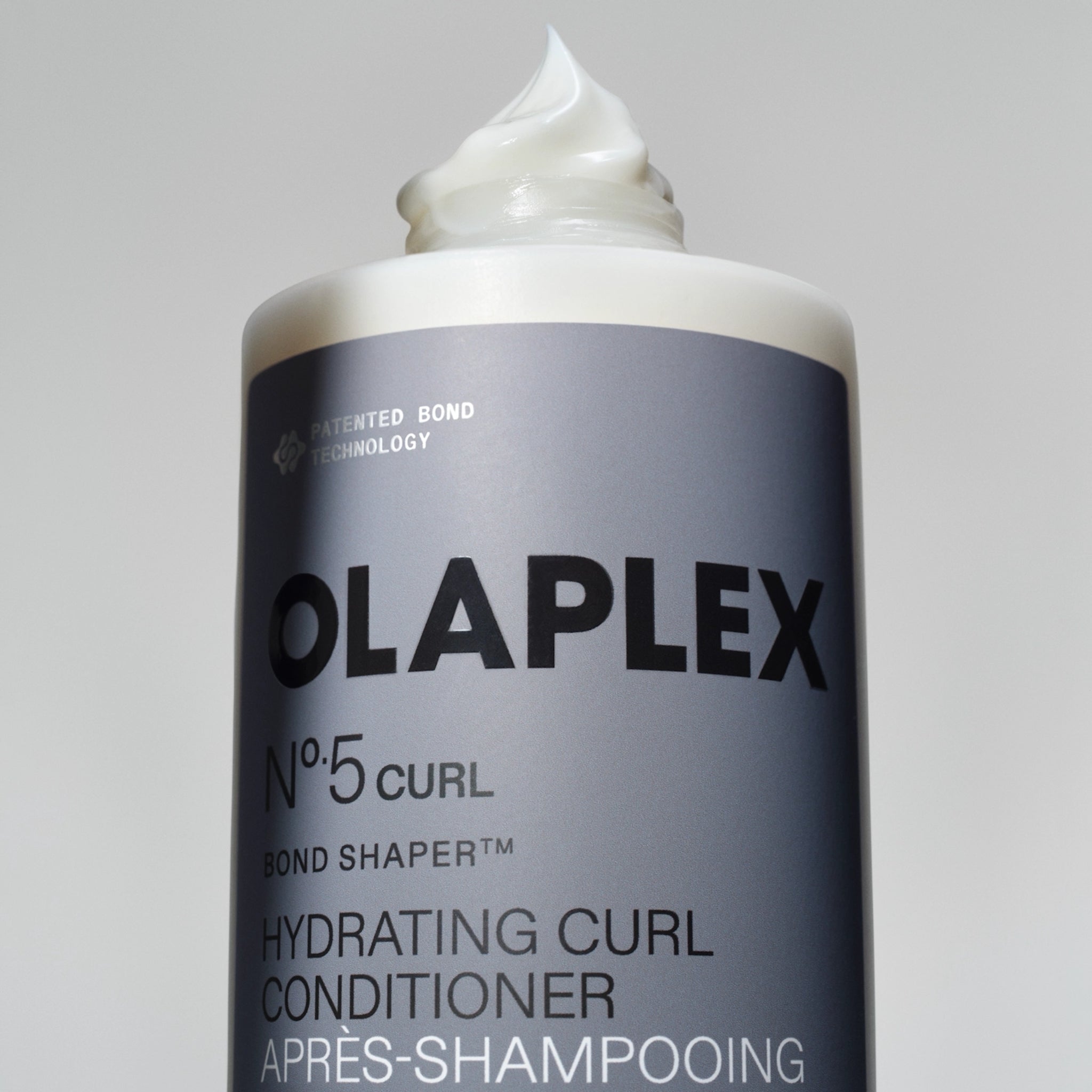 Olaplex Nº.5 Curl Bond Shaper hydrating curl conditioner i grå tube med cremet hvid produkt på toppen.